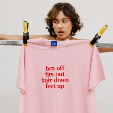 Różowa koszulka z napisem na wieszaku na pranie