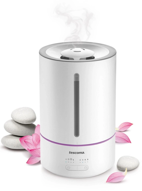 Biały nawilżacz powietrza obok kamieni i płatków kwiatów