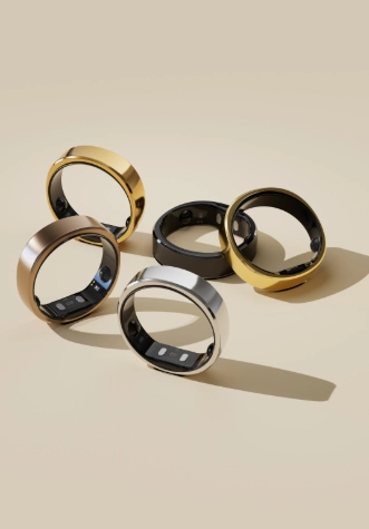 Pięć pierścieni w różnych kolorach na beżowym tle