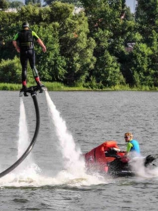 Mężczyzna na wakeboardzie oraz mężczyzna na skuterze wodnym