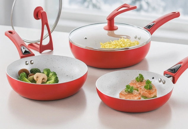 Trzy czerwone patelnie z pokrywkami i jedzeniem