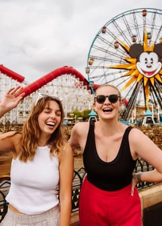 Dwie dziewczyny na tle diabelskiego młyna z Mickey Mouse