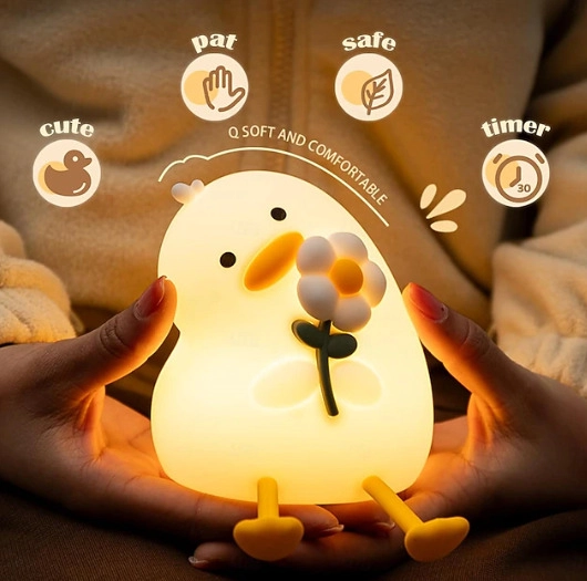 Lampka w kształcie kaczki ze stokrotką trzymana w dłoniach