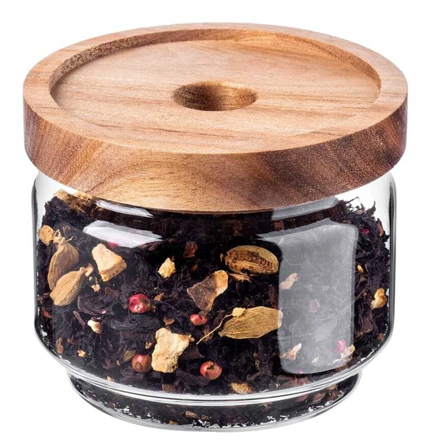 Szklany słoik z drewnianym wieczkiem z herbatą w środku