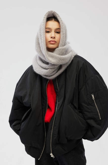 Dziewczyna w czarnej kurtce i z szarym szalikiem na szyi i głowie