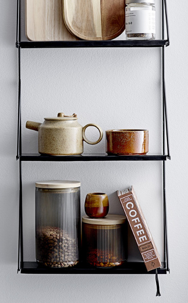 Minimalistyczna otwarta półka na ścianie z ceramiką, pojemnikami i deskami