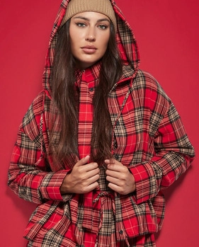 Brunetka w brązowej czapce i kurtce w czerwoną szkocką kratę