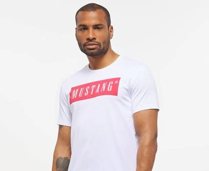 Mężczyzna w białej koszulce z czerwonym logo Mustanga