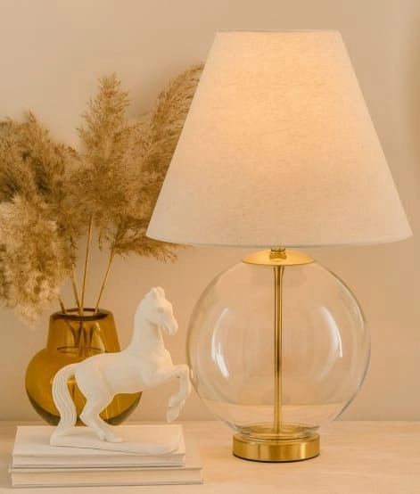 Lampka z jasnym abażurem i szklanym dołem, rzeźba konia i ozdobne liście