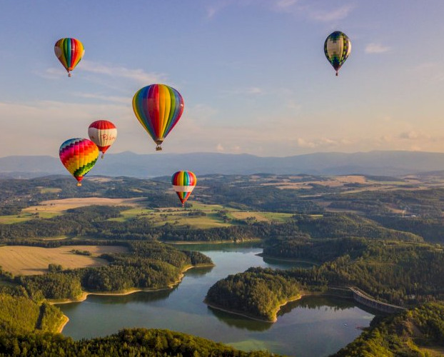 Balony lecące o zachodzie słońca nad rozlewiskiem