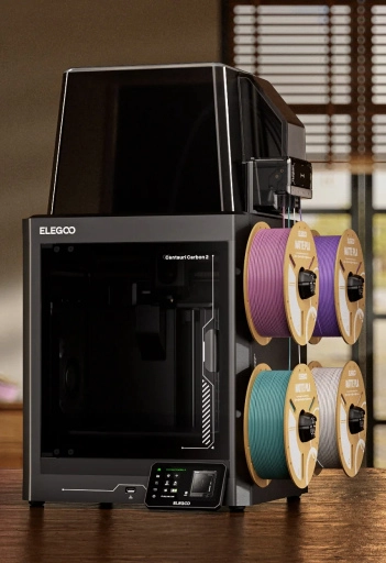 Czarna drukarka 3D na drewnianej podłodze