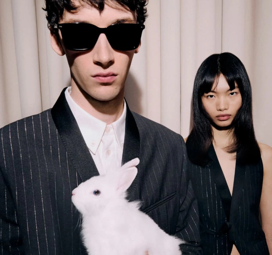 Chłopak i dziewczyna w czarnych strojach i z białym królikiem