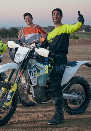 Mężczyźni w strojach motocyklowych i z motocyklami