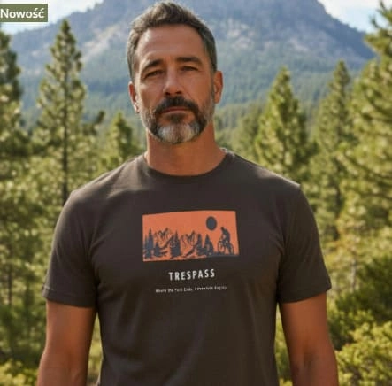 Mężczyzna w szarej koszulce na tle lasu i gór