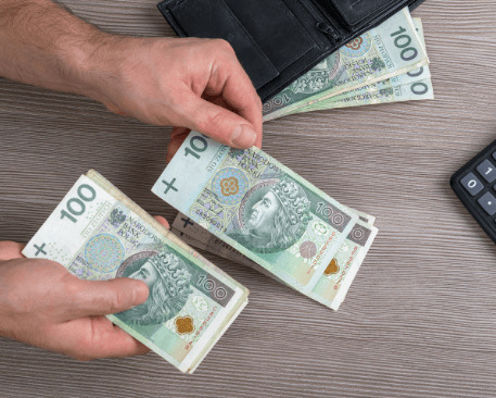 Ręce z pieniędzmi i czarnym portfelem