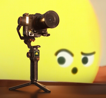 Aparat fotograficzny na trójnogu na tle żółtej kuli