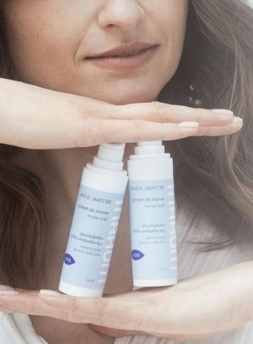 Kobieta trzymająca dwa kosmetyki w białych opakowaniach