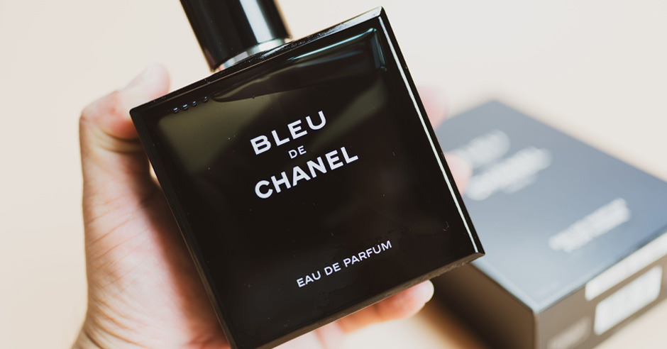 Czarna fiolka z perfumami w męskiej dłoni